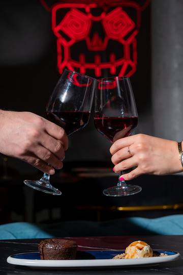 Brindis con vino tinto bajo la calavera de Bacanal